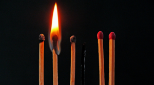 A group of matches with one lit up.